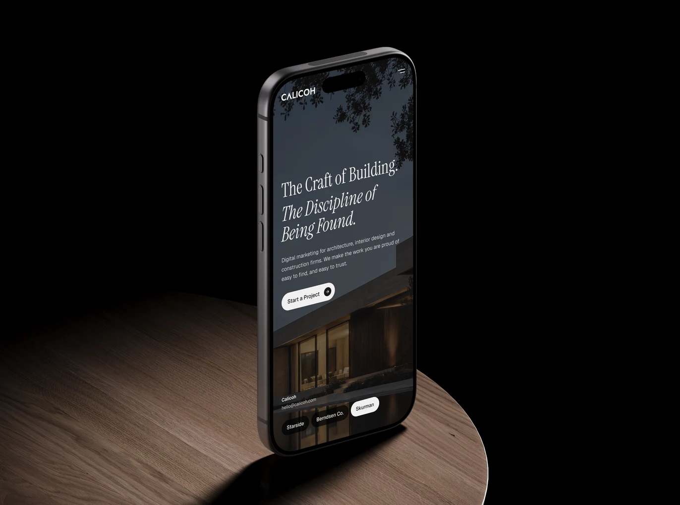 Calicoh website on an iPhone resting on a wooden table