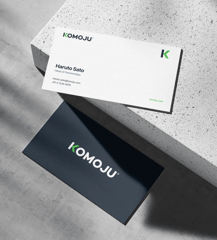 KOMOJU business cards on a concrete block